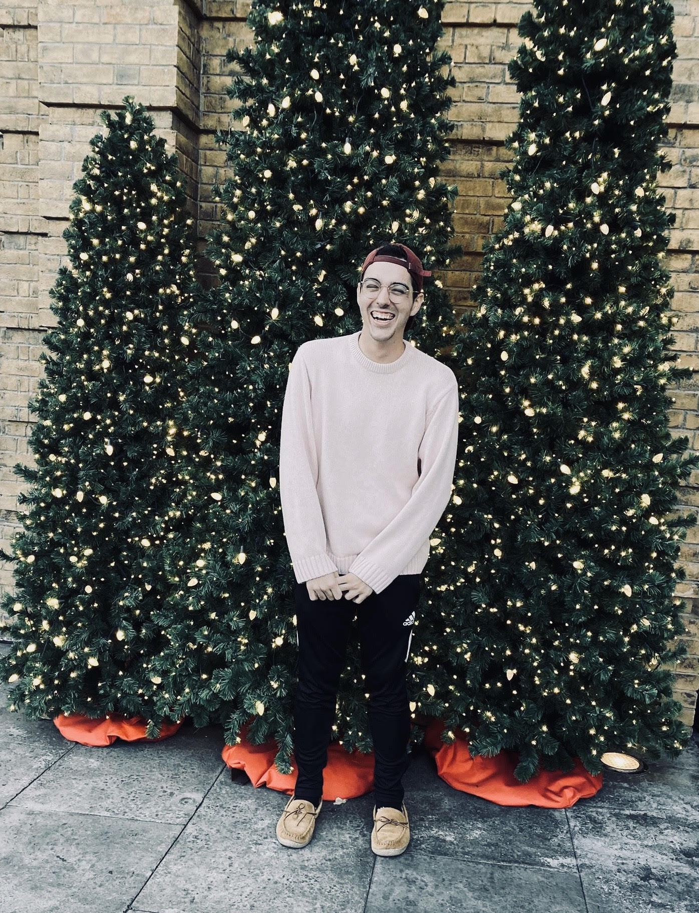A picture of myself smiling in front of christmas trees